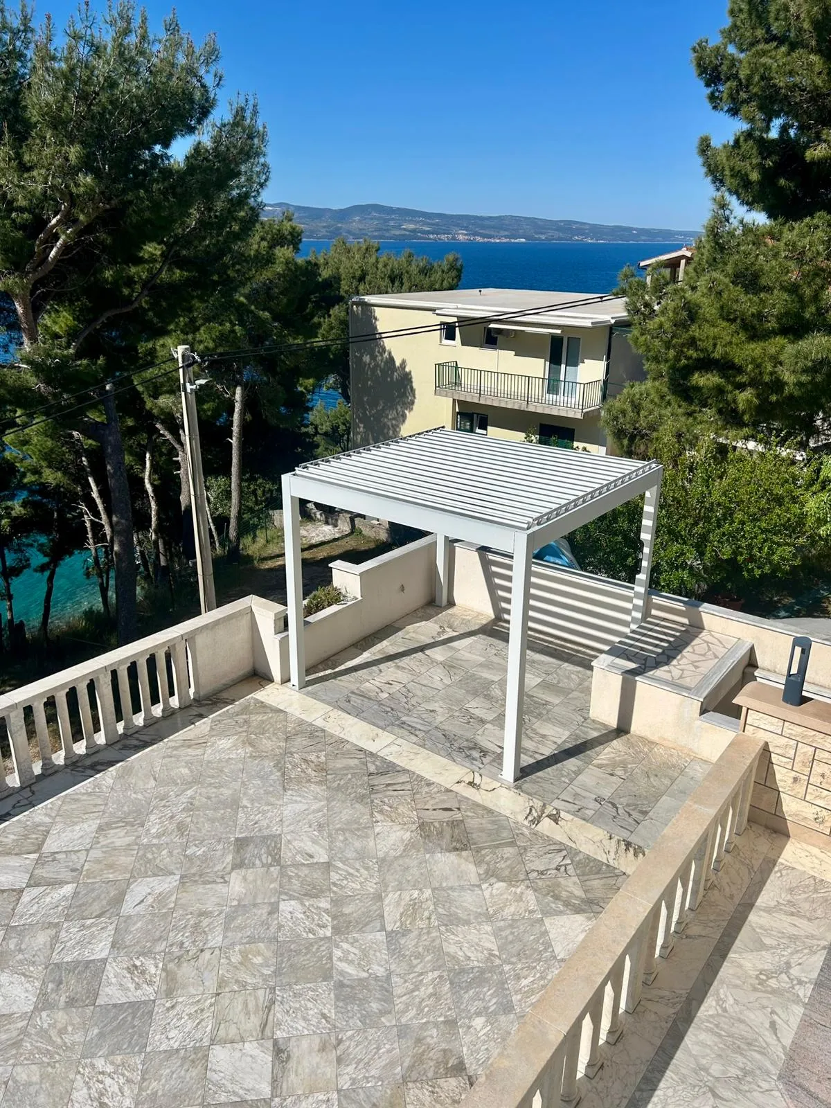 PergoMaxx pergola — širi pogled na samostojeću konstrukciju s morskim vidikom