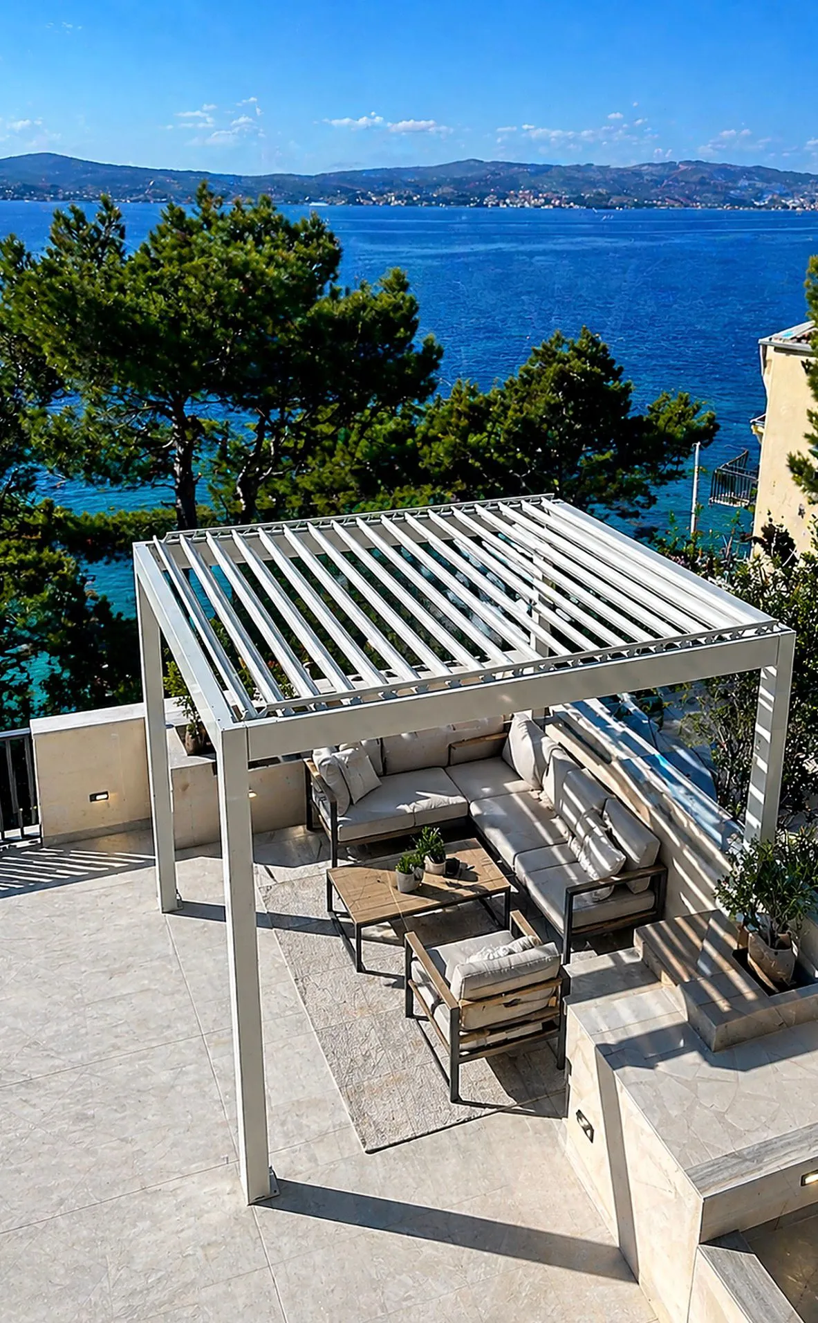 PergoMaxx Motion pergola — natkrivena dnevna zona s pogledom na obalu i otoke